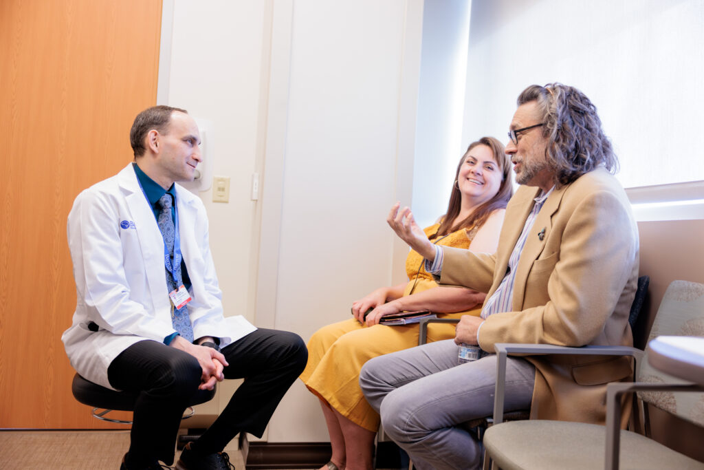 Dr. Vladimir Shvarts interacting with patient Randy Ehlers and the patient's friend in the clinic.