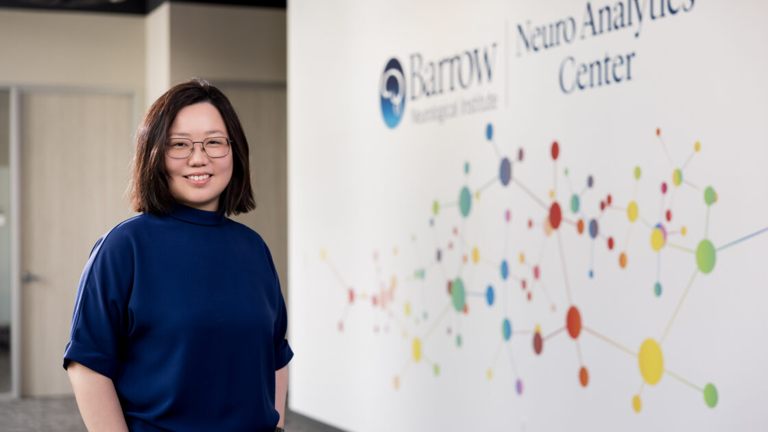 neurologist chia ling phuah standing in front of a working area in the barrow neuroanalytics center