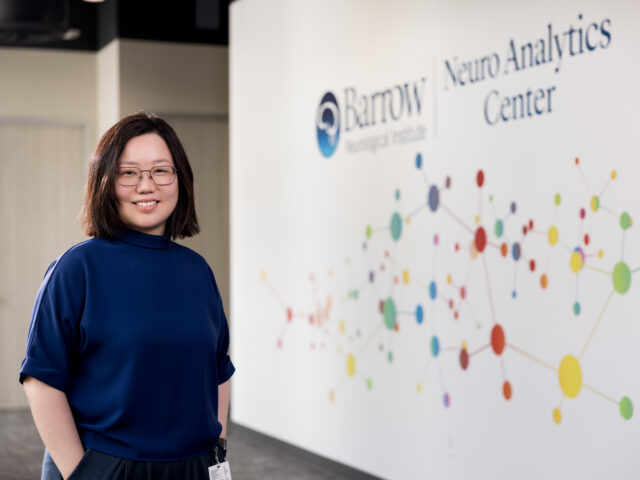 neurologist chia ling phuah standing in front of a working area in the barrow neuroanalytics center