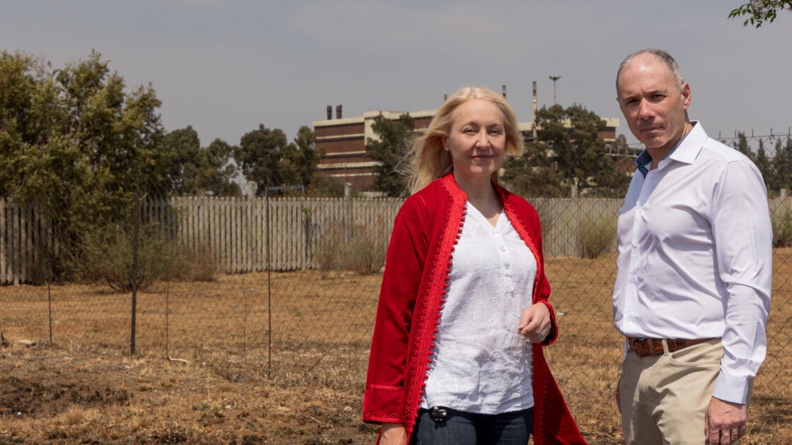 Dr. Brad Racette and Dr. Gill Nelson are pictured outside of the manganese smelter in Meyerton, South Africa.