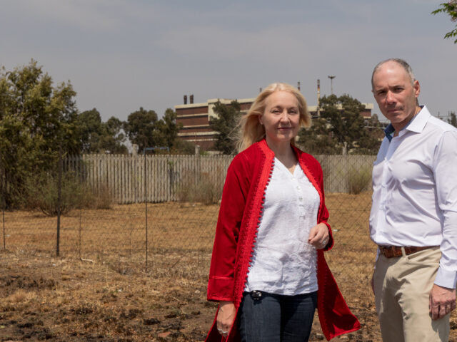 Dr. Brad Racette and Dr. Gill Nelson are pictured outside of the manganese smelter in Meyerton, South Africa.