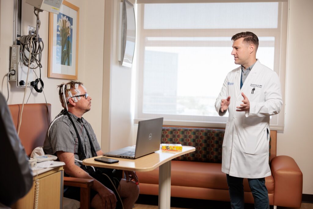 neurologist david harris talks to a patient in the epilepsy monitoring unit