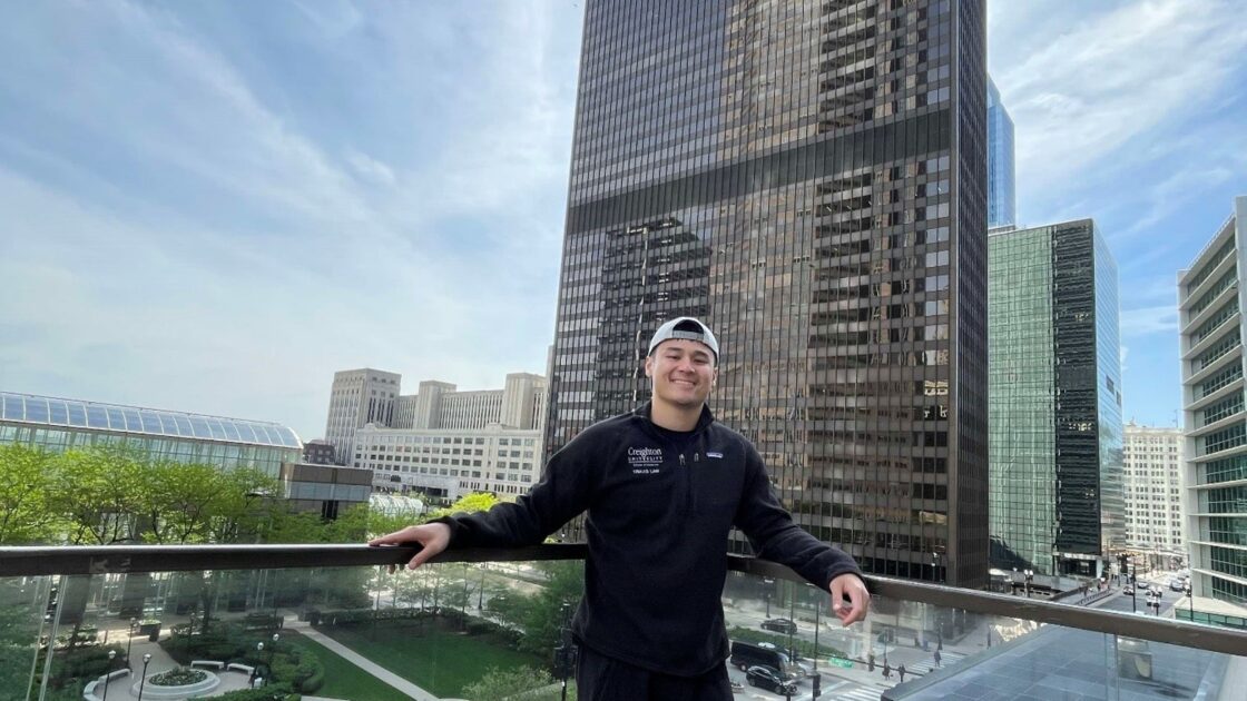 travis lam on a balcony overlooking a skyscraper